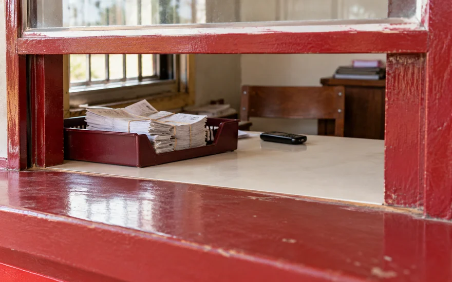 Transaction slips seen through the service opening of a payment booth