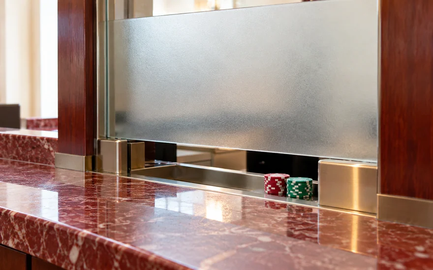 Gaming chips visible beneath a closed casino cashier window