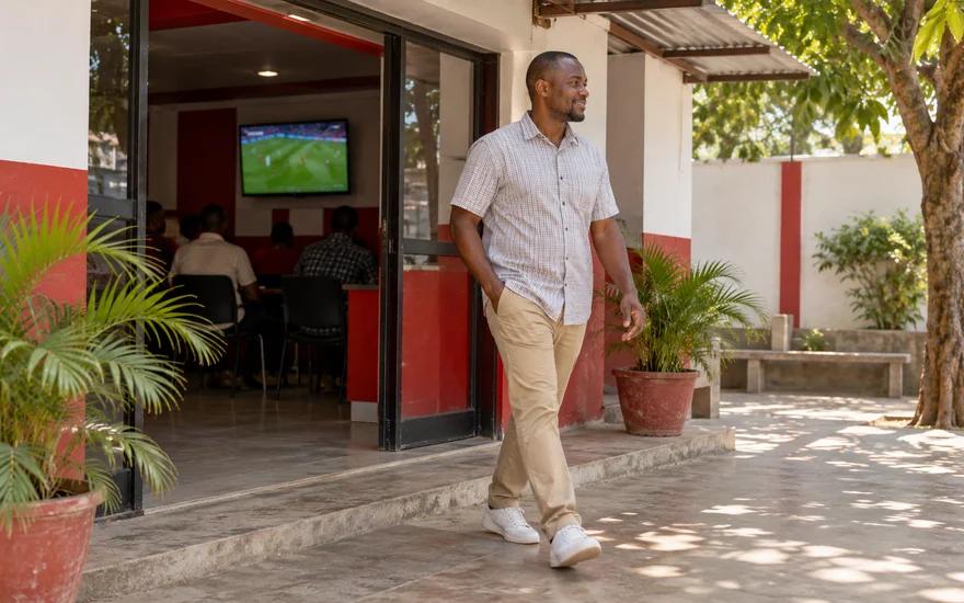An adult leaving an unbranded betting hall for a quiet courtyard